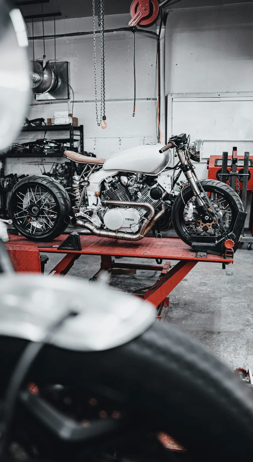 Motorrad steht auf einer Hebebühne in einer Werkstatt