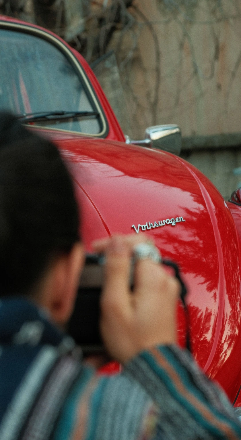 Fotografische Dokumentation am Kotflügel eines roten VW Käfers