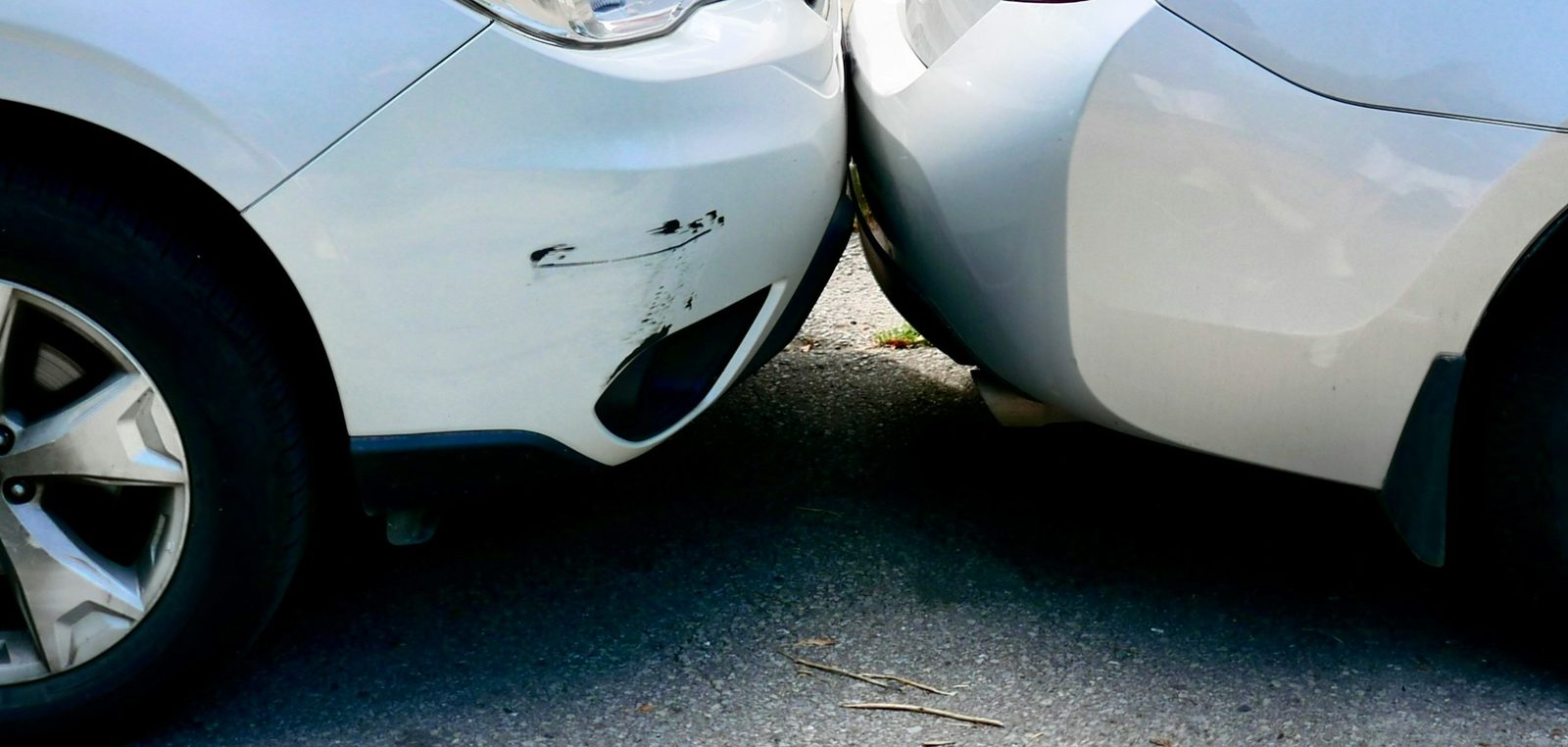 Zwei Autos nach einem leichten Auffahrunfall, schwarze Schrammen am vorderen Stoßfänger