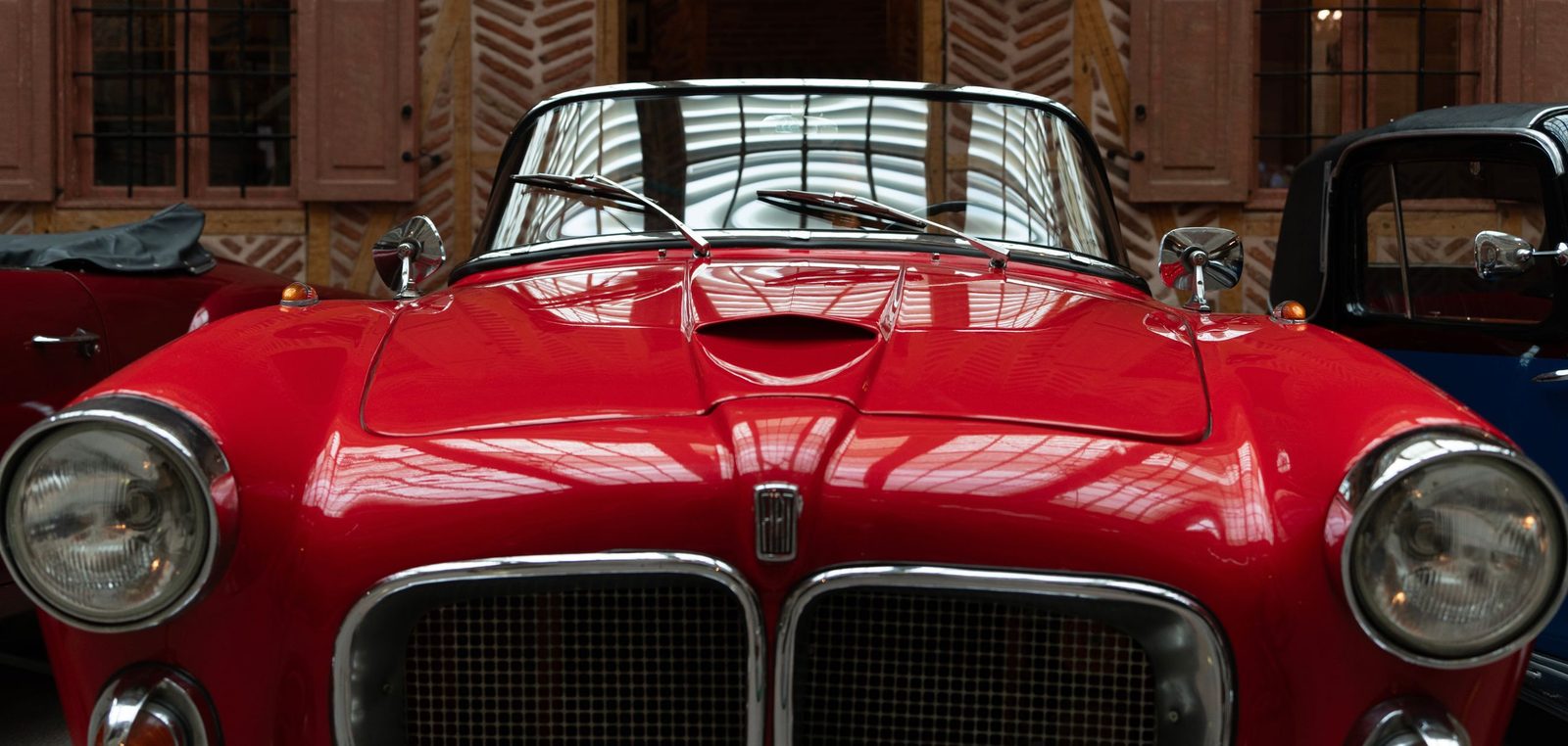 Roter Oldtimer von vorn in einer Halle