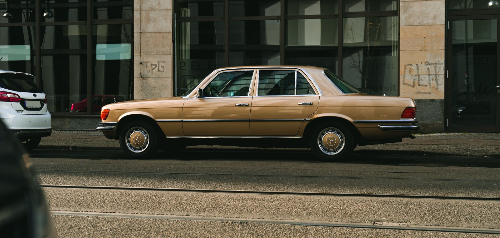 Goldene Mercedes S-Klasse der Baureihe W116 am Straßenrand