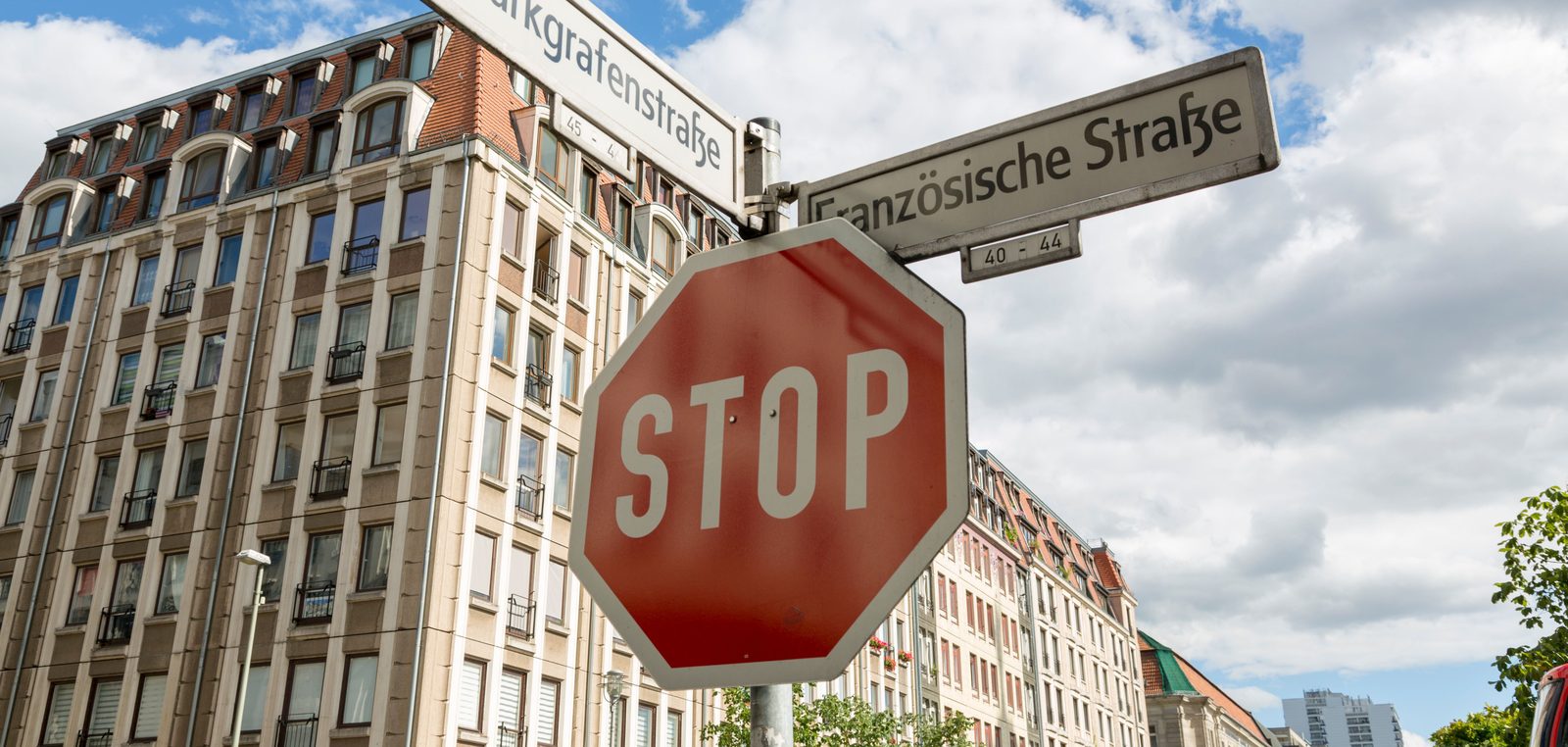 Stoppschild an einer Berliner Kreuzung unter den Straßenschildern Markgrafenstraße und Französische Straße
