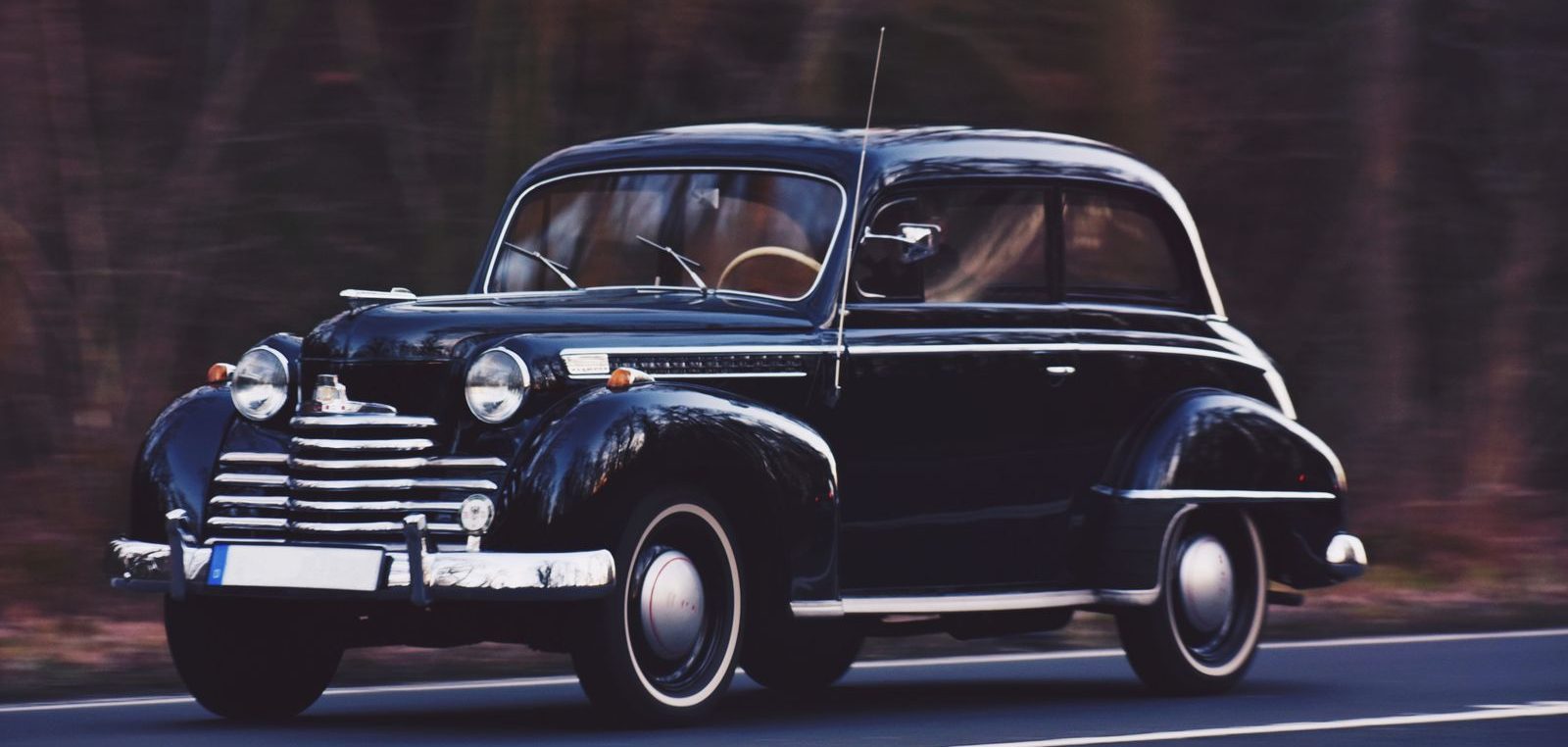 Dunkelblauer Opel Olympia als gepflegter Klassiker in Fahrt