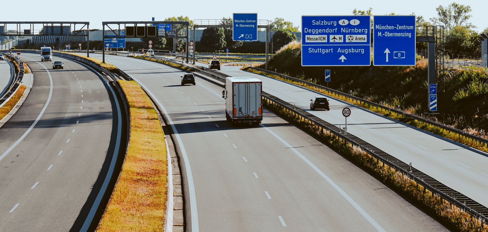 Mehrspurige Autobahn mit Auffahrt und Wegweisern in Deutschland